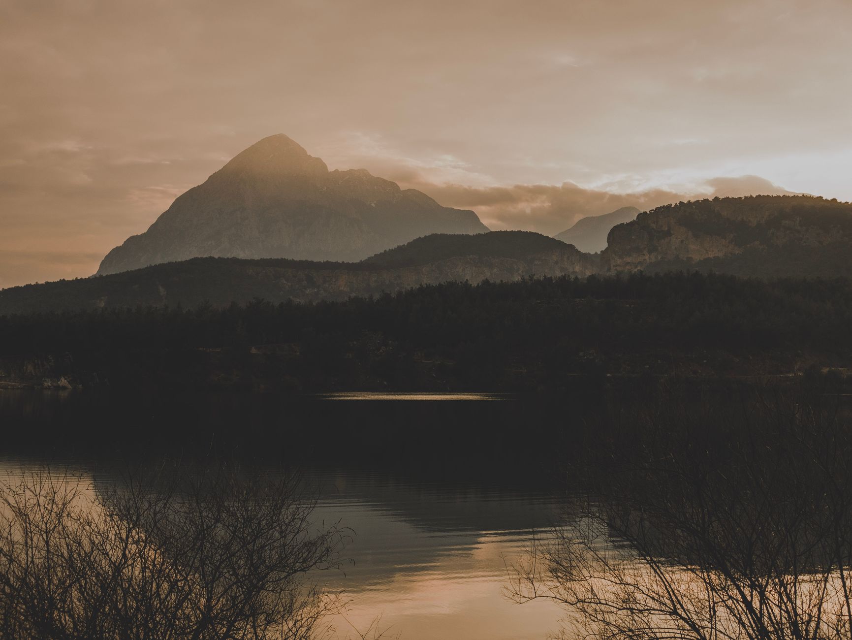 Tranquil mountain lake reflecting morning sunlight in deep wilderness