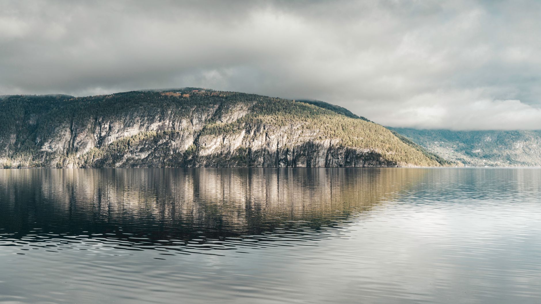 Pristine blue waters of a Norwegian fjord beneath dramatic cliffs